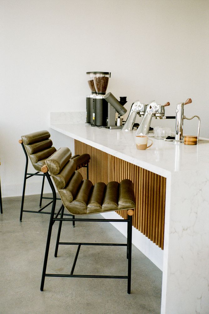 Lynx Coffee marble bar with olive leather stools and the espresso machine