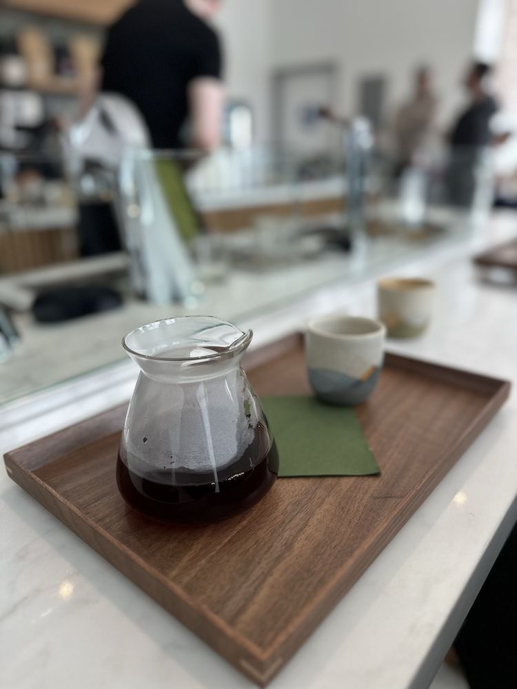 Single-origin pour over served in a glass carafe on a walnut tray at the Lynx bar